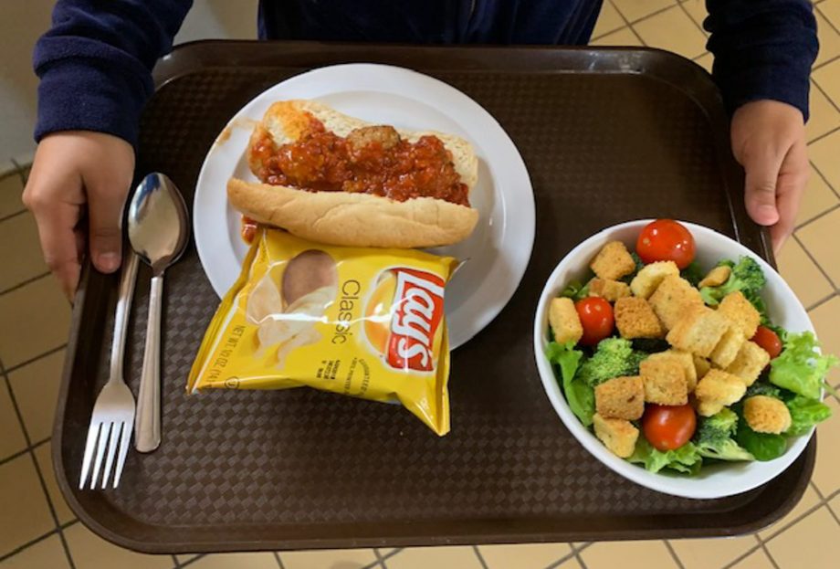 Meatball sandwich, chips and fresh salad