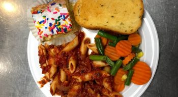 Penne Pasta Bolognese cooked in our own sauce recipe, Baked garlic bread, Seasonal veggies and yellow cake