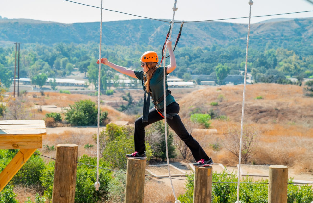 Crossing bridge of vertical wooden poles on the Adventure Hill course