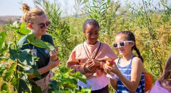 Two campers and two staff holding fruit Citrus Grove at the Recreational Ranch Program