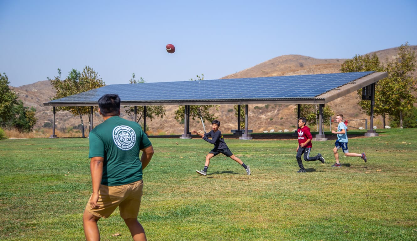 Boys playing football with staff