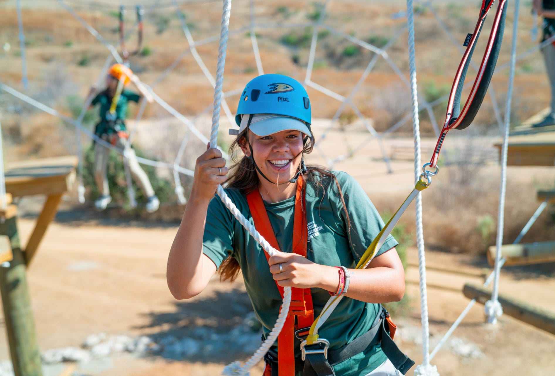Woman on the spider web section of the Adventure Hill challenge course