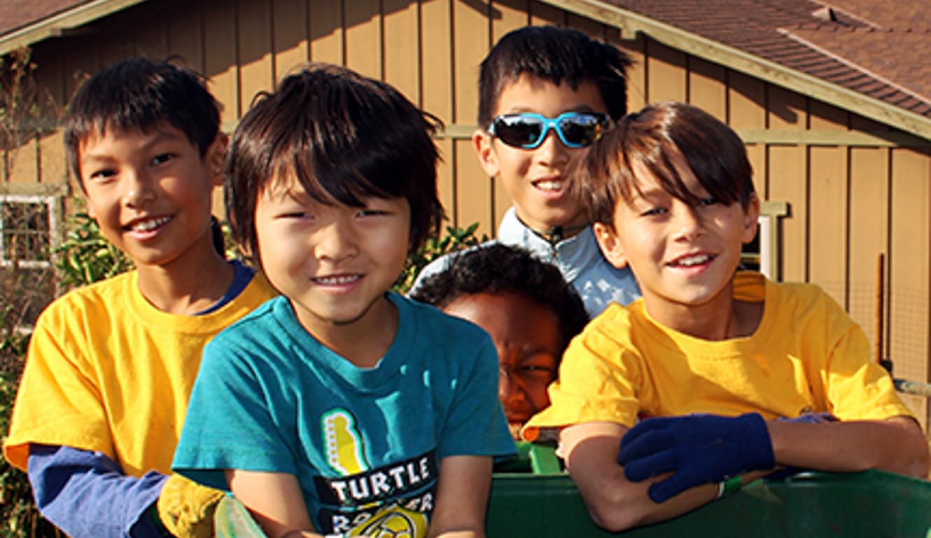 Kids smiling by recycling bin at Irvine Ranch's Day of Service